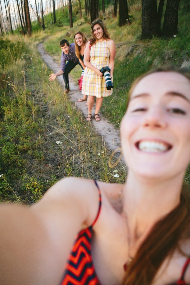 A woman takes a selfie in the forest with her friends