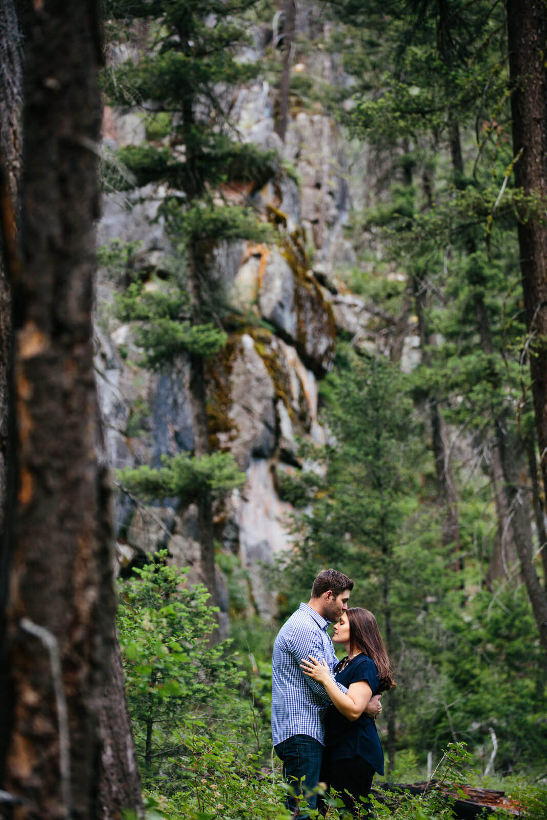 A couple kisses in the woods during their engagement session in Rock Creek Montana
