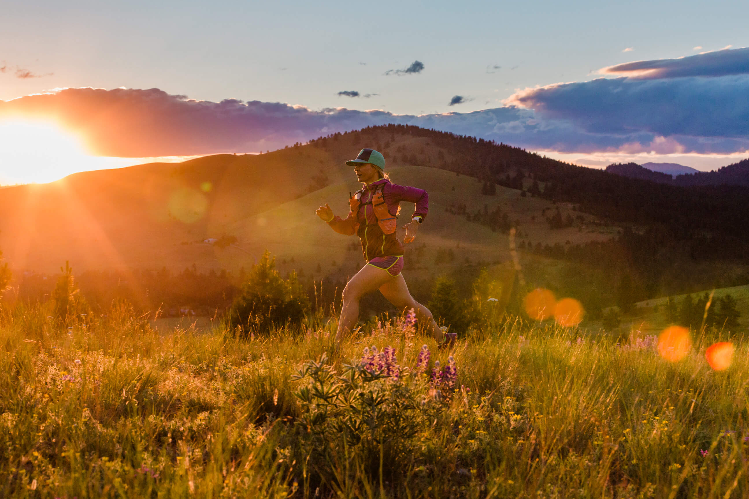 A woman trail runner runs at sunset in Missoula Montana
