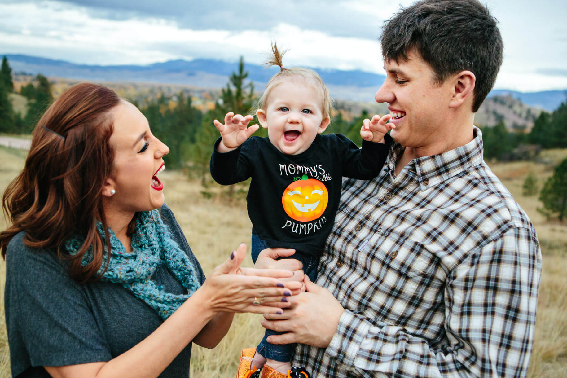A mother and father look at their baby and laugh during their family photos in Missoula Montana