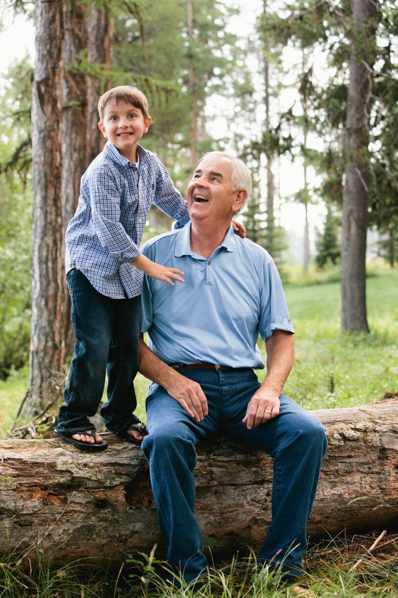 A grandfather laughs at his grandson's antics during their family session in Seeley Lake Montana