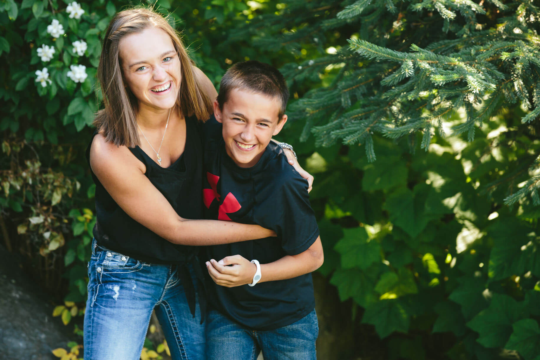A sister and brother laugh and wrestle with one another during their family portraits at Seeley Lake Montana
