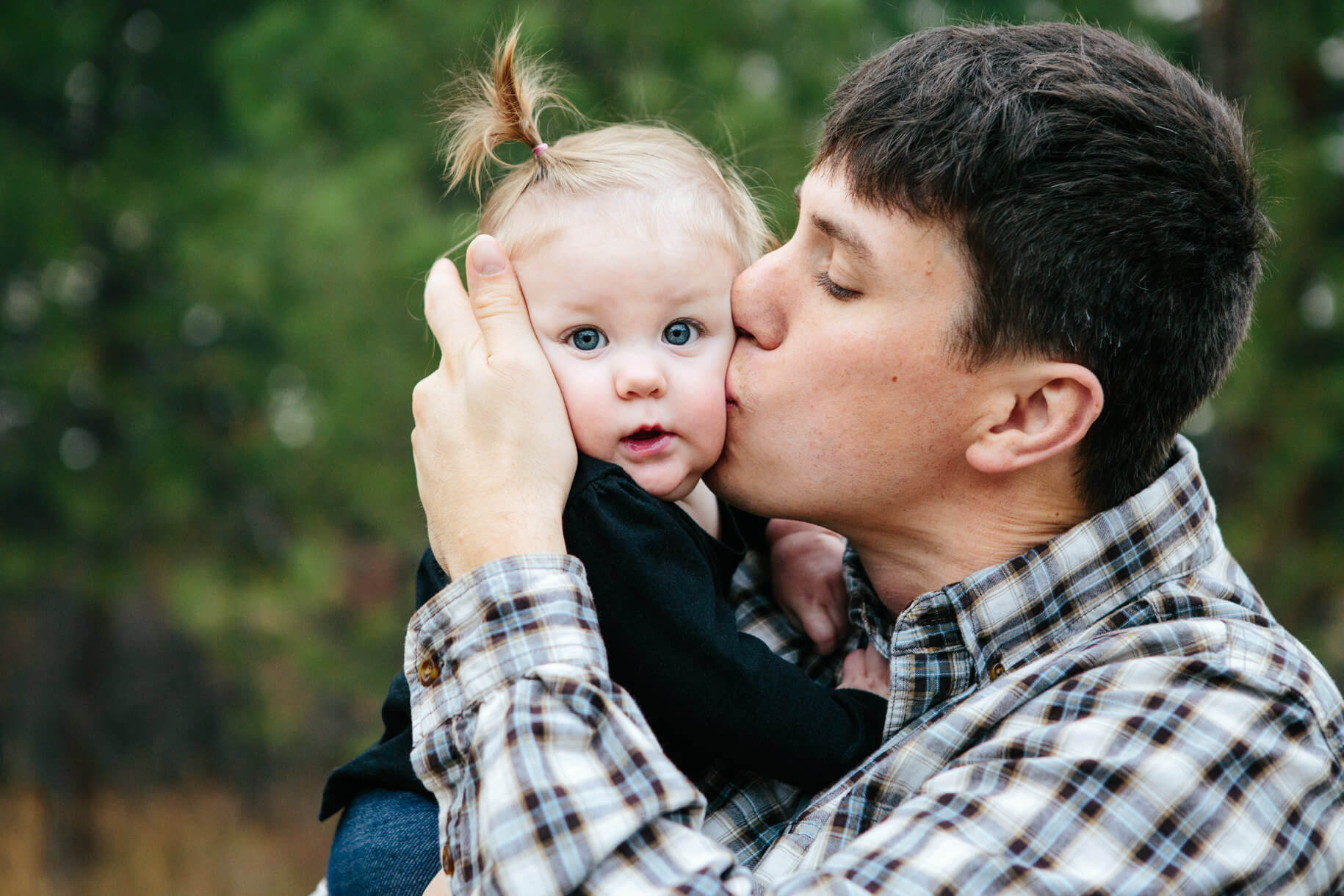 A father kisses his baby girl on the cheek during their family photos in Missoula Montana
