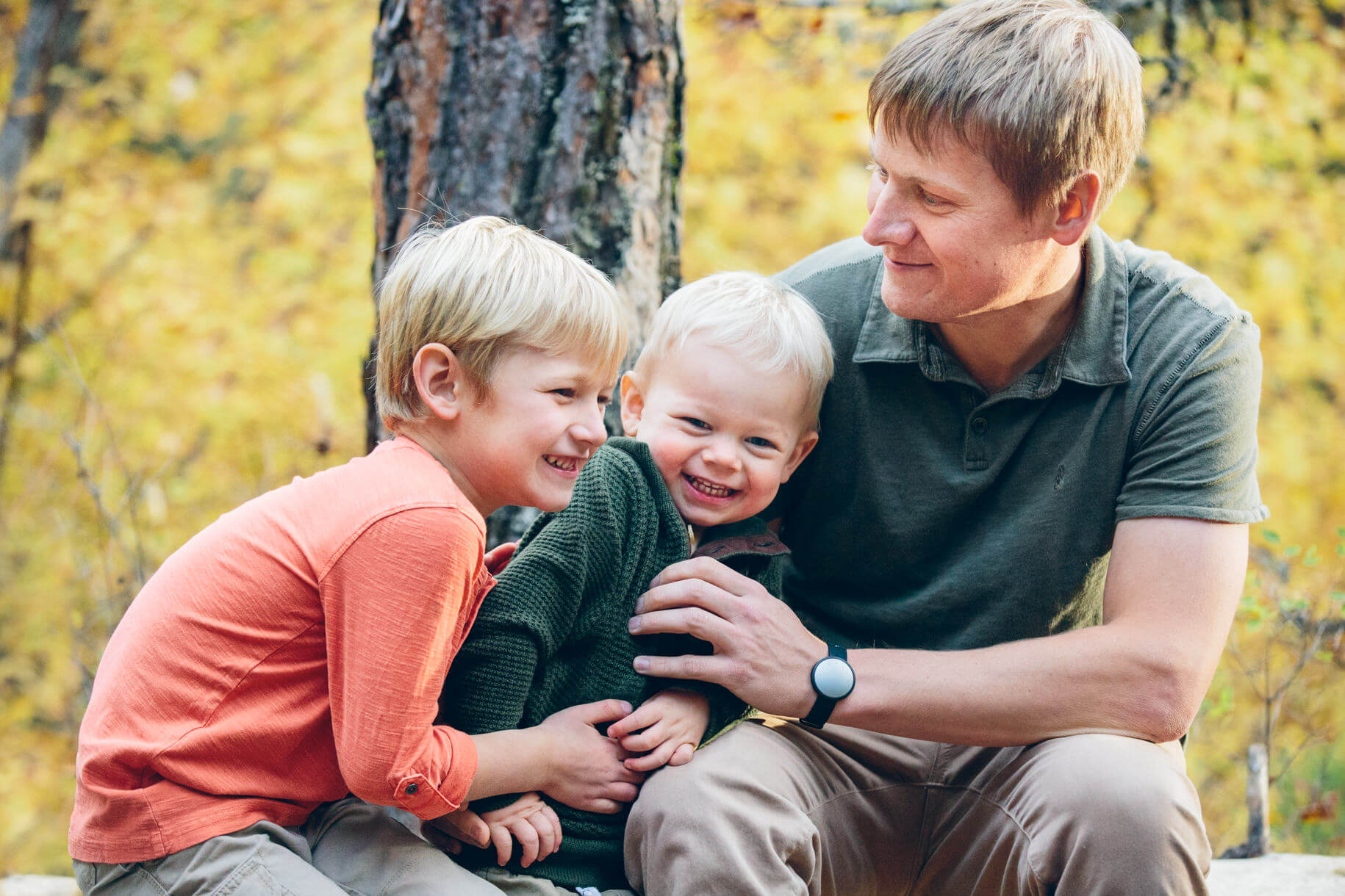 A father and his sons tickle each other and laugh during their family photos in Missoula Montana