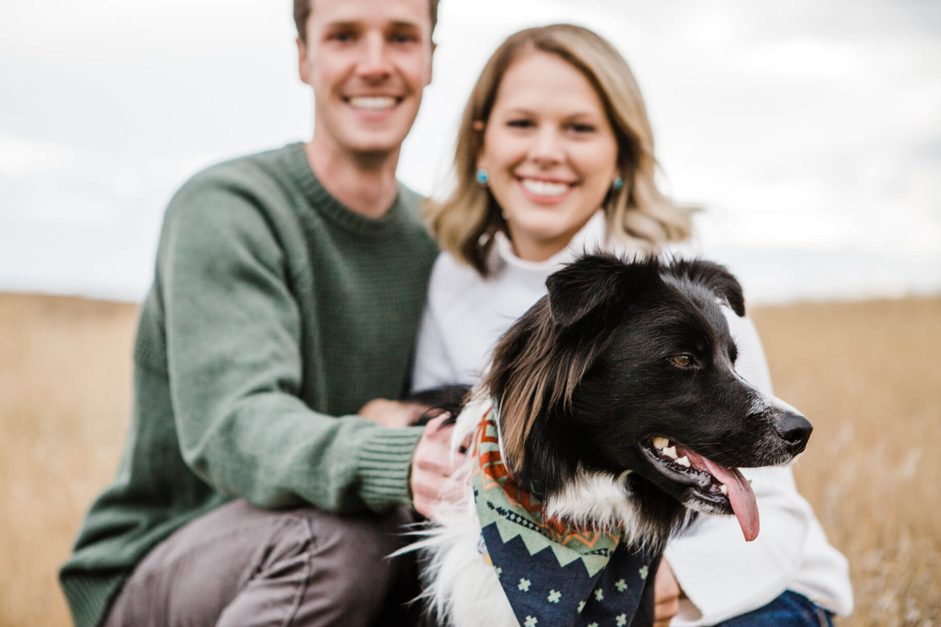 A husband and wife smile with their border collie dog during their portrait session in Missoula Montana