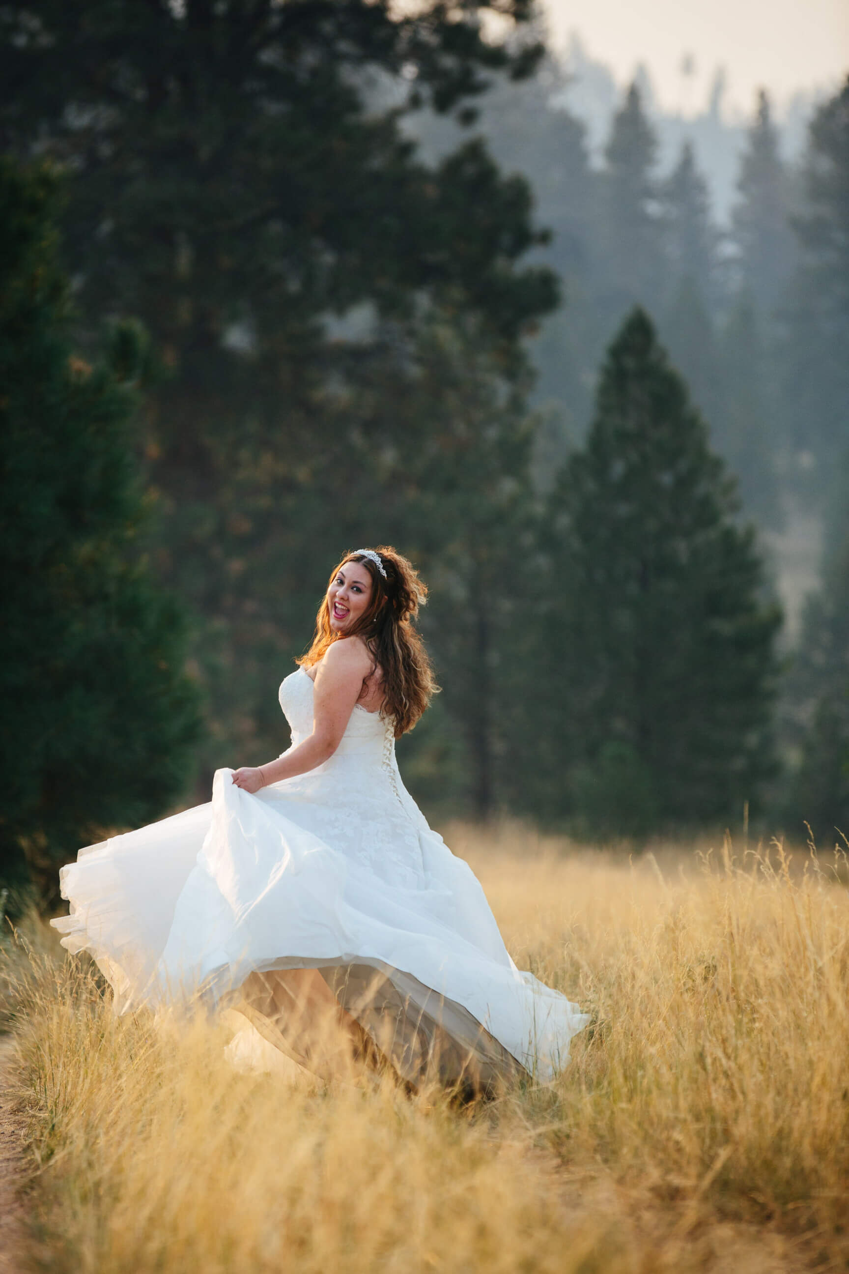 A bride spins in her wedding dress in tall grass during her rock the dress photos in Missoula Montana