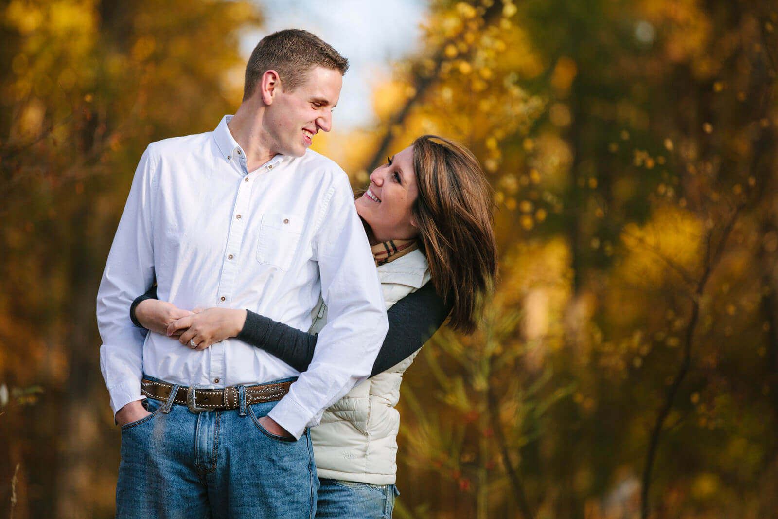 A couple hugs and smiles at one another during their autumn engagement session in Missoula Montana