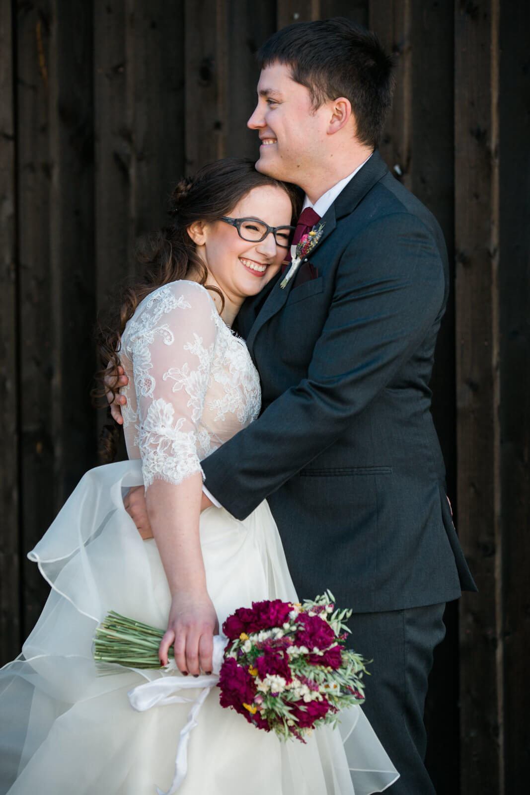 A bride and groom hug and smile during their wedding at The Barn on Mullan in Missoula Montana.