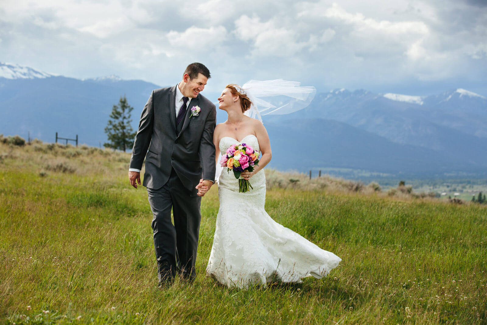 A bride and groom smile at each other during their Stone Tower Estate wedding in Stevensville Montana