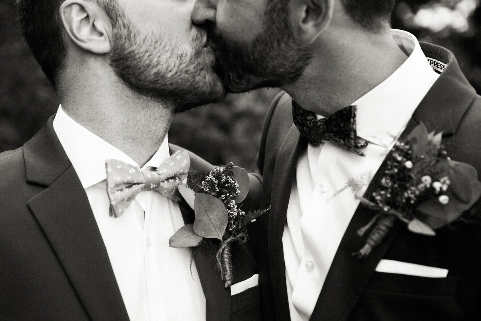 Two grooms kiss at their wedding in Kimberly British Columbia at the Kimberley Alpine Resort