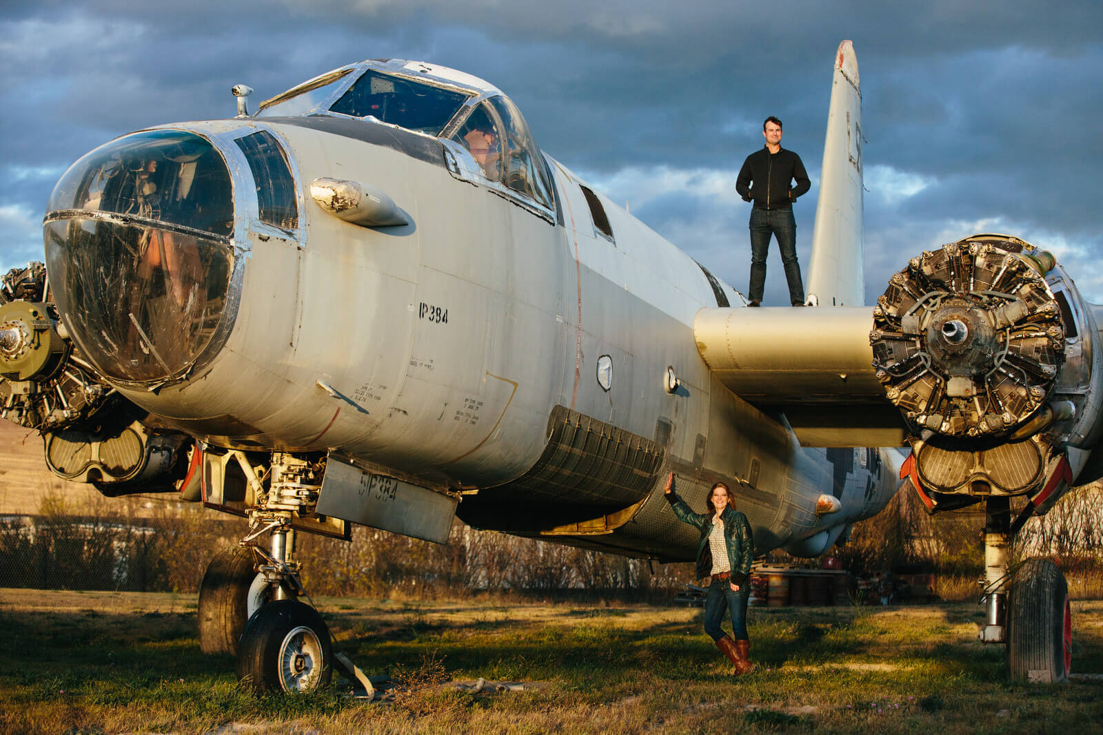 A couple stands on and near an old airplane during their engagement photos in Missoula Montana