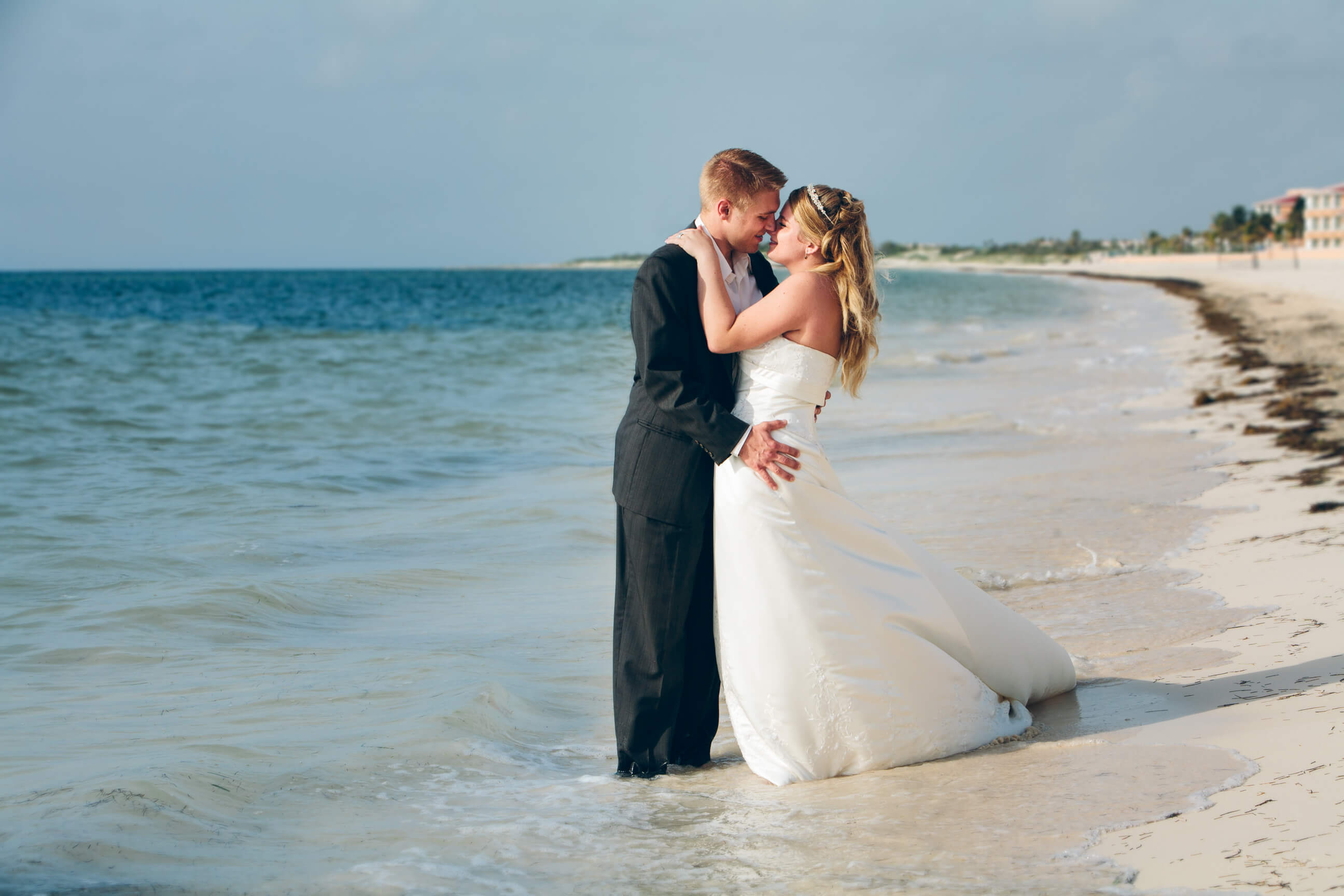 A bride and groom kiss on the beach during their rock the dress photos in Cancún Mexico.