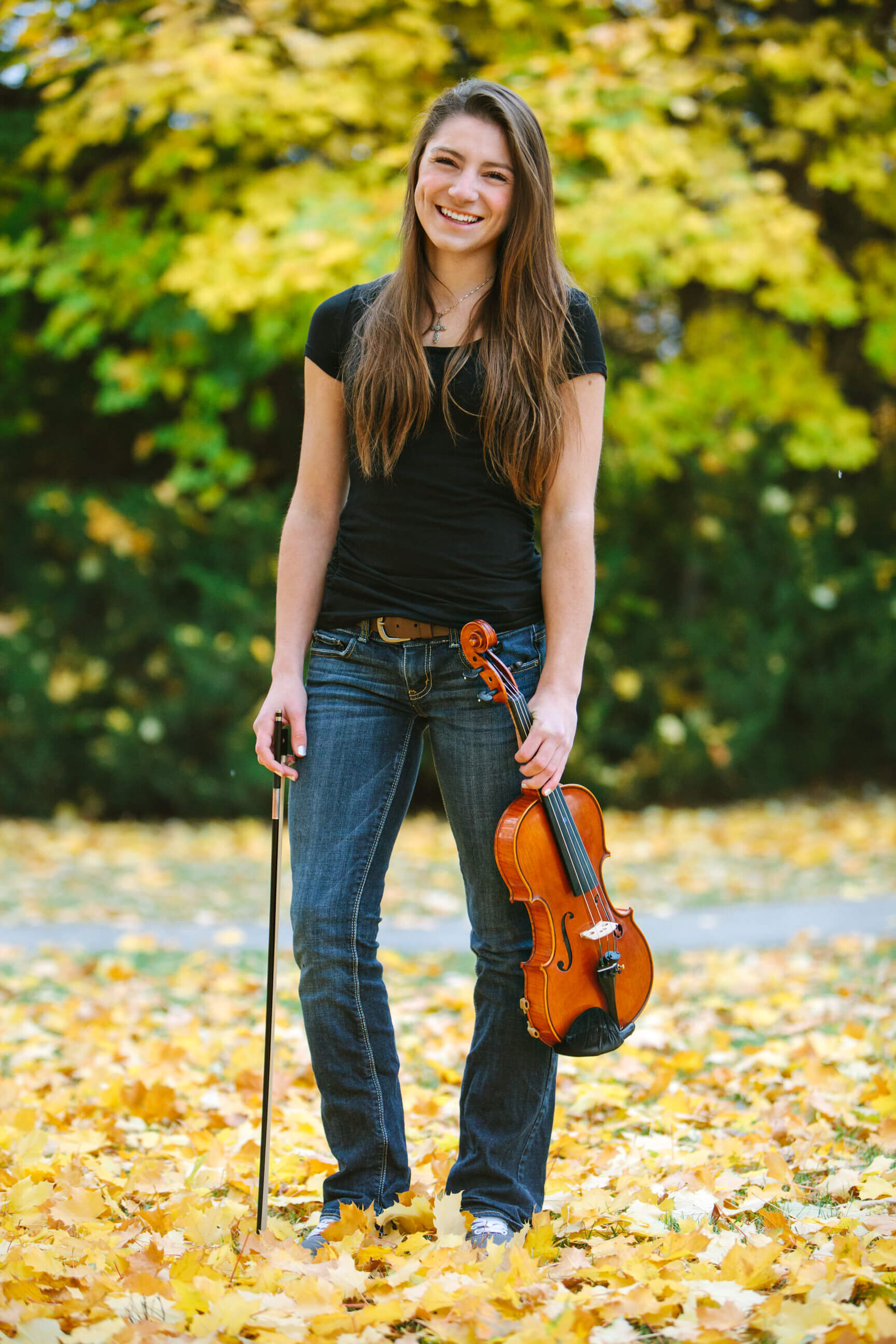 A senior girl holds her violin during her senior photos in Missoula Montana