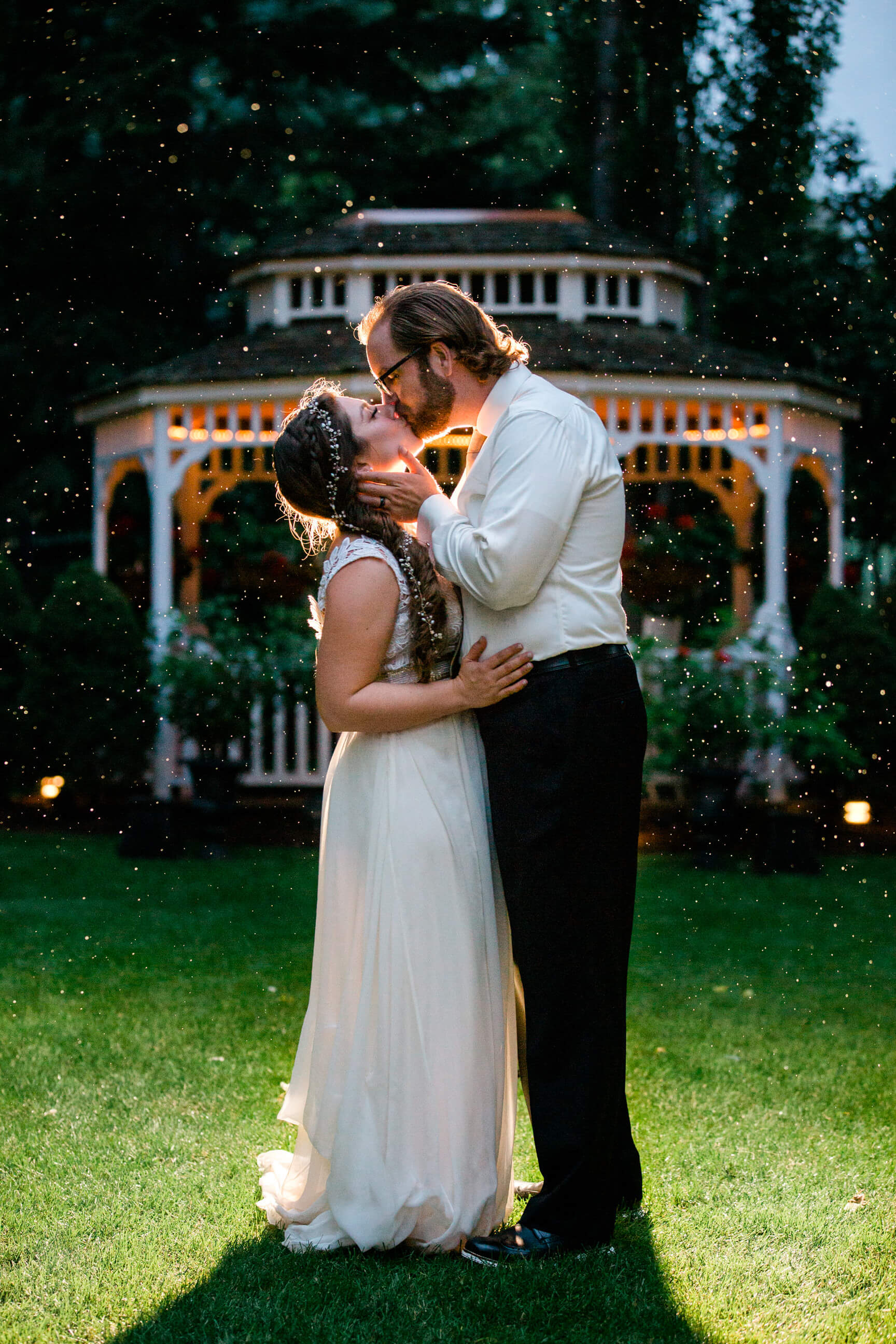 A bride and groom kiss in the rain during their wedding at the Gibson Mansion in Missoula Montana