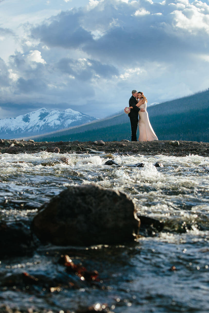 A groom kisses his bride at Lake McDonald in Glacier National Park during their Montana elopement